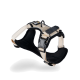 Beige und schwarzes Hundegeschirr mit verstellbaren Riemen und einem metallenen D-Ring zur Leinenbefestigung, vor einem weißen Hintergrund präsentiert.