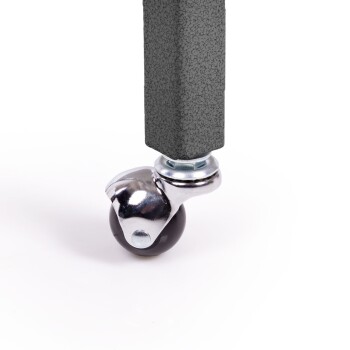 Nahaufnahme eines schwarzen Gummirades, das an einem strukturierten grauen Pfosten befestigt ist, und das seine verchromte Drehhalterung zeigt.