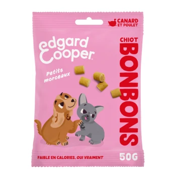 Un sac rose de friandises pour chiens Edgard Cooper avec un chien et un chiot en dessin animé, avec le texte "Petits morceaux" et "BONBONS" affiché en évidence.