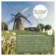 Bild einer traditionellen Windmühle, umgeben von grünem Gras und Blumen, mit Text, der hochwertiges regionales Haustierfutter bewirbt.
