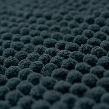 Nahaufnahme einer strukturierten, dunkelgrauen Oberfläche eines Haustierbettes mit kleinen, runden, plüschigen Erhebungen für Komfort.