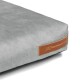 Ecke eines grauen Haustierbettes mit glatter Textur und einem braunen Lederetikett, das "REXPRODUCT.COM" anzeigt.