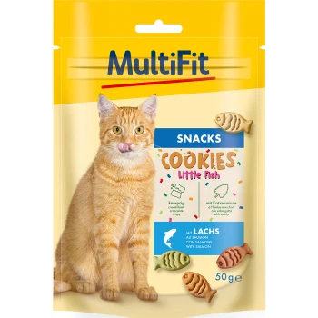 Zabawny pomarańczowy kot liże wargi przed żółtą torbą przekąsek oznaczoną "MultiFit Cookies Little Fish," z przysmakami w kształcie ryb.