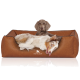 Ein gemütliches braunes Hundebett mit einem weißen und braunen Australian Shepherd, der bequem liegt, mit dem Logo "KNUFFELWUFF" auf der Vorderseite.