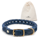 Ein geflochtenes blaues Lederhundehalsband mit einer goldenen Schnalle, begleitet von einem beigen Zugbeutel mit dem Logo 'Freudentier.'