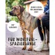 Ein gestromter Hund auf einem gepflasterten Weg, angeleint von einer Person in schwarzen Jeans und weißen Sneakers. Text: "Für Wohlfühl-Spaziergänge", "Rundes Design."