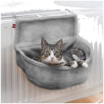 Ein gemütliches graues Katzenbett, das an einem Heizkörper montiert ist, mit einer entspannten Katze, die bequem darin ruht.