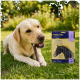 Yellow Labrador lying on grass chewing a stick beside a packaged pet treat box labeled 'PREMIERE. Deluxe' (Chew Stick).