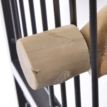 Nahaufnahme einer Holzstange, die an einem schwarzen Metall-Vogelkäfig befestigt ist, die die Textur des Holzes und der Metallstäbe zeigt.