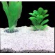 Aquariumsubstrat mit zwei künstlichen Pflanzen: einer hohen, federartigen grünen Pflanze und einer buschigen grünen Pflanze, vor einem schwarzen Hintergrund.