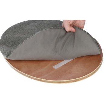 Hand hebt graue Stoffabdeckung von rundem Holz-Tierbettgestell ab und zeigt darunter Klettverschlussstreifen.