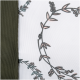 Nahaufnahme eines Haustierzubehörs mit einem floralen Muster aus Blättern und Beeren auf einem weißen Hintergrund, umrandet von olivgrünem Stoff.