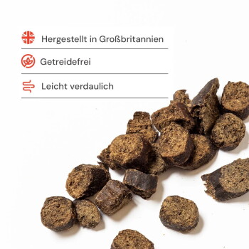 Runde braune Tierleckerlis auf weißem Hintergrund; deutsche Aufschriften: „Hergestellt in Großbritannien“, „Getreidefrei“, „Leicht verdaulich“.