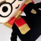 Plush toy resembling a character with large round glasses, a red and yellow striped scarf, and a black outfit.