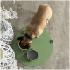 Ein Hund frisst aus einer weißen Schüssel, die mit Futter gefüllt ist, die auf einem runden grünen Teppich steht. Eine zweite leere graue Schüssel ist in der Nähe.