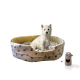 Ein gemütliches Haustierbett mit einem weichen Pfotenabdruckdesign, in dem ein kleiner weißer Hund sitzt, begleitet von einem beigen Haustierzubehör.