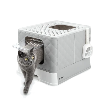 Eine graue Katze mit gelben Augen verlässt eine moderne, stilvolle Katzentoilette mit einem Diamantmuster, markiert mit "lionto."