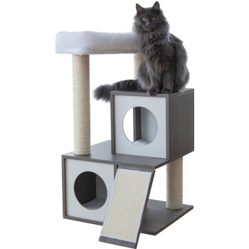 Eine flauschige graue Katze sitzt auf einem modernen Katzenbaum mit zwei Kratzpfosten, würfelförmigen Verstecken und einer strukturierten Rampe.