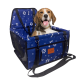 Ein blauer Autositz für Haustiere mit weißen Pfotenabdrücken und Knochen, mit einem kleinen Hund, der darin sitzt und mit einem Geschirr gesichert ist.