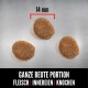 Drei Stücke Haustierfutter auf einer metallischen Oberfläche, jeweils etwa 14 mm groß, mit dem Text "GANZE BEUTE PORTION FLEISCH | INNEREIEN | KNOCHEN" darunter.