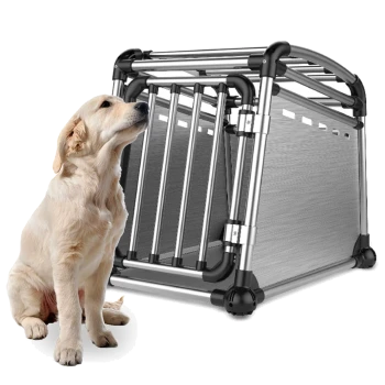 Golden-Retriever-Welpe sitzt neben einer silbernen Aluminium-Transportbox für Hunde mit Rohrrahmen und Netzwänden.