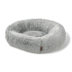 Panier rond pour animal en peluche grise avec bords relevés et petite étiquette marron sur le côté, sur fond blanc.