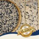 Schale mit gemischtem Vogelfutter auf Holzplanken, verstreute Samen, goldenes Siegel mit der Aufschrift 'Seit über 15 Jahren' und 'Best Quality'.