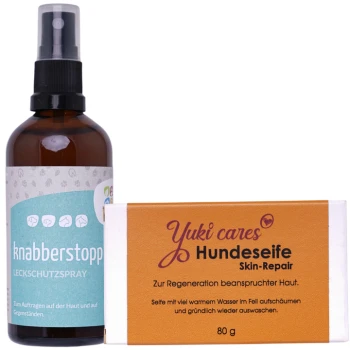 Eine braune Sprühflasche mit der Aufschrift "knabberstopp Leckschutzspray" neben einer Seife "Yuki cares Hundeseife Skin-Repair" mit deutschen Anweisungen.