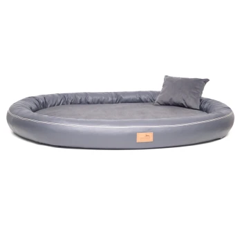 GILBERT ORTHO Soft LATEX - Orthopädisches Hundebett aus Kunstleder schwarz/ graphit 85 cm, 13 cm, 65 cm Graues ovales Haustierbett mit einem weichen Innenraum und einem kleinen passenden Kissen, mit einem beigen Etikett mit dem "tierlando"-Logo.