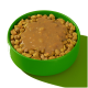 Eine grüne Futterschüssel für Haustiere, gefüllt mit trockenem Futter, das mit einer dicken, braunen, gravyartigen Sauce bedeckt ist, vor einem hellgrünen Hintergrund.