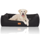 Ein Golden Retriever liegt bequem auf einem schwarzen Hundebett mit einem Holzschild, auf dem "HUTTEWOR" steht.