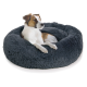 Ein gemütliches, rundes, dunkelgraues Hundebett mit einer flauschigen Textur, in dem ein entspannter Hund bequem ruht.