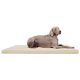 Ein grauer Weimaraner-Hund, der auf einem cremefarbenen Hundebett liegt und aufmerksam zur Seite schaut.