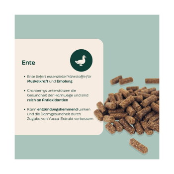 Braune Entenpellets neben einer deutschen Infokarte mit der Überschrift 'Ente', die Muskelunterstützung, Preiselbeeren, Antioxidantien und Yucca erwähnt.