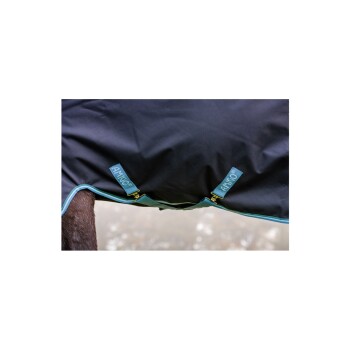 Eine Nahaufnahme einer schwarzen Pferdedecke mit blauen Akzenten, mit zwei Etiketten, die an den Seiten "AMIGO" beschriftet sind, über dem Rücken eines Pferdes drapiert.