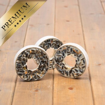 Drei Premium-Vogelfutter-Donuts mit einem weißen Grund und schwarzen Sonnenblumenkernen, auf einer Holzoberfläche präsentiert.