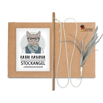 Verpackung für Katzenspielzeug mit einer Cartoon-Katze in Brille und Schal, beschriftet mit "KATER KASIMIR STOCKANGEL + BÄNDERANHÄNGER," enthält einen Stock und Bänder.