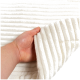 Eine Hand hält eine weiche, weiße Haustierdecke mit gerippter Textur, die ihr plüschiges Material zeigt.