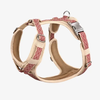 Hundegeschirr June S Ein beiges Haustiergeschirr mit einem roten geometrischen Muster, mit verstellbaren Riemen und Metallclips für eine sichere Befestigung.