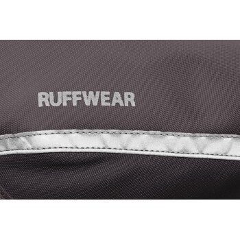 Nahaufnahme eines grauen Stoffes mit dem Wort "RUFFWEAR", das in silberner Schrift prominent dargestellt ist, mit silberner Einfassung.