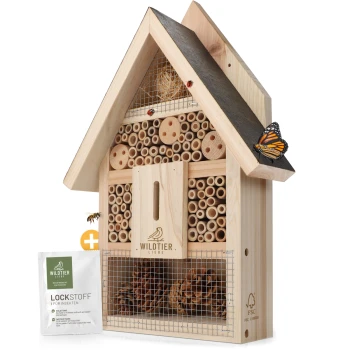 Holzinsektenhotel mit verschiedenen Röhren und Fächern, mit einem Schmetterling auf dem Dach und einem Paket, das mit "LOCKSTOFF" beschriftet ist.