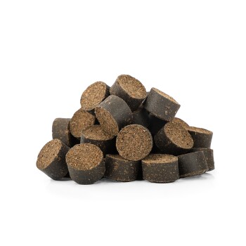Ein Haufen runder, dunkelbrauner Haustier-Nahrungsergänzungsmittel oder Leckerlis, die ihre strukturierte Oberfläche und kreisförmige Form vor einem weißen Hintergrund zeigen.