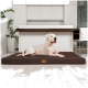 Ein weißer Hund, der auf einem braunen Haustierbett in einer modernen Küche mit minimalistischer Gestaltung und grünen Pflanzen im Hintergrund entspannt.