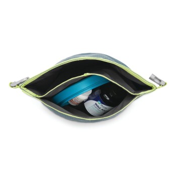 Eine graue und grüne Haustierbedarfstasche, die geöffnet ist und eine blaue Leine, eine Flasche flüssiges Ergänzungsmittel und ein Glas mit der Aufschrift "Wild Algen Lachsöl" zeigt.