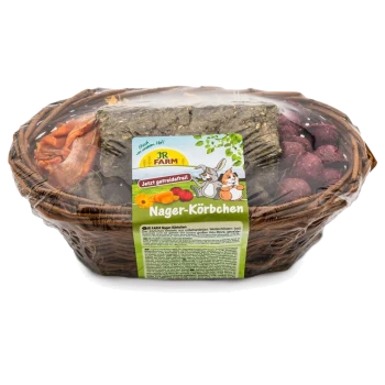 Ein Korb aus Weiden mit bunten Haustierleckereien und Heu, beschriftet mit "JR FARM Nager-Körbchen" und "Jetzt getreidefrei".