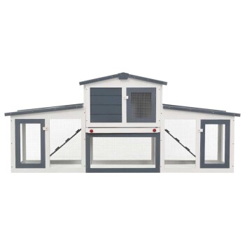 Eine Nahaufnahme eines weißen und grauen Haustiergeheges mit einer Netzttür, einer Holzrampe im Inneren und einem geneigten Dach.