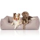 Zwei Hunde liegen zusammen auf einem weichen, beigen Haustierbett, auf dem das Logo "KNUFFELWUFF" sichtbar ist.