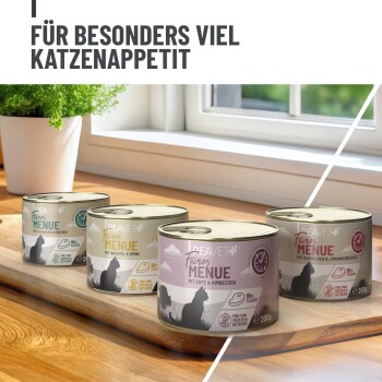 Vier Dosen Peavet Feines Menü Katzenfutter mit verschiedenen Geschmacksrichtungen auf einem Holzbrett am Fenster, Text auf Deutsch.