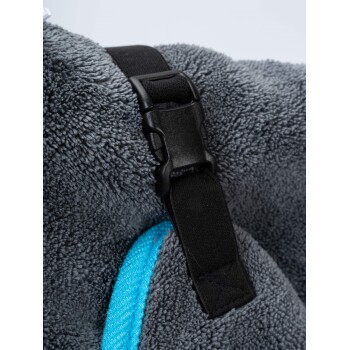 Nahaufnahme eines grauen Haustierhandtuchs mit einem schwarzen Schnallenriemen und einem blauen Rand, das seine weiche Textur und den Verschlussmechanismus zeigt.