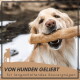 Ein Golden Retriever hält glücklich einen großen Kauknochen im Mund, mit dem Text "VON HUNDEN GELIEBT für langanhaltendes Kauvergnügen" darunter.